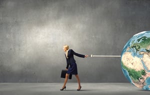 Young businesswoman with suitcase pulling Earth planet with lead. Elements of this image are furnished by NASA